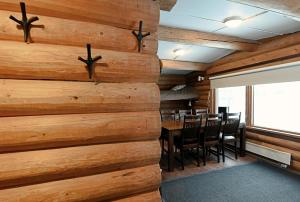 a room with a wooden wall with a table and chairs at Classic Log Cabin Ski-in Ski-out in Levi