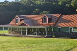 una casa con techo naranja y patio en GameRoom, HotTub, Piano, 5mi to OldManCave - Hocking Hills Copper House en Laurelville