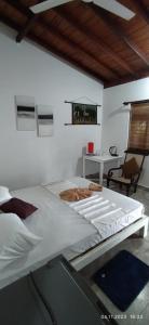 a large white bed in a room with a desk at Full Moon Resort in Unawatuna