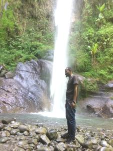 een man die voor een waterval staat bij Kioga home stay in Arusha