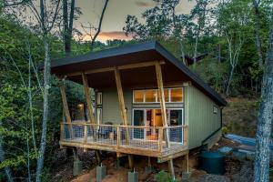 a green tiny house in the woods at Pilot Cove in Pisgah Forest