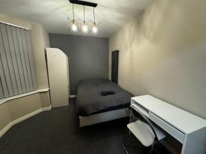 ein kleines Schlafzimmer mit einem Bett und einem Schreibtisch in der Unterkunft SUPER 5 Bedroom House Sleeps 11! in Hull