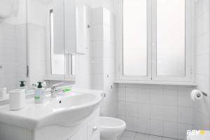 a white bathroom with a sink and a toilet at Piazza Bologna Holiday House in Rome