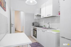 a white kitchen with white cabinets and a sink at Piazza Bologna Holiday House in Rome