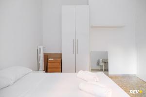 a white bedroom with a white bed with towels on it at Piazza Bologna Holiday House in Rome