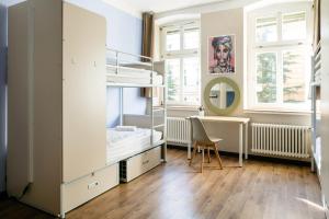 1 dormitorio con litera y escritorio en EastSeven Berlin Hostel, en Berlín