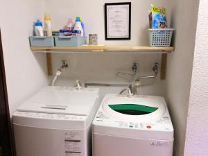 uma lavandaria com uma máquina de lavar roupa e uma máquina de lavar roupa em Hakuba Goryu Pension Kurumi em Hakuba