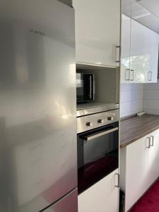 una cocina con horno de acero inoxidable y microondas en Ismail Wohnung 2 Zi. Kranichstein en Darmstadt