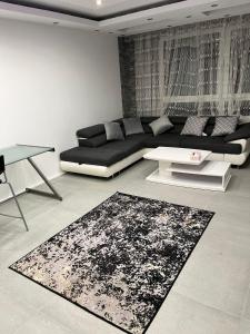 sala de estar con sofá negro y alfombra en Ismail Wohnung 2 Zi. Kranichstein en Darmstadt