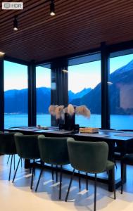 a dining room with a table and chairs and a large window at VILLA KRISTINA / ÅNDALSNES in Torvik