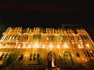 un grand bâtiment avec des lumières allumées la nuit dans l'établissement Hotel Tokyo Palace, à Jaisalmer