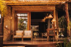a porch with two chairs and a table and a window at Vila Cerrado in Alto Paraíso de Goiás