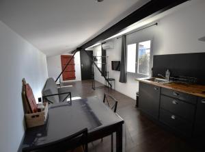 sala de estar con mesa y cocina en Studio industriel à 50 m de la plage et du port, en Mèze