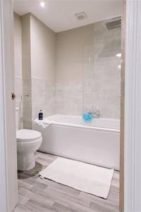 ein Badezimmer mit einer weißen Badewanne und einem WC in der Unterkunft SUPER 5 Bedroom House Sleeps 11! in Hull