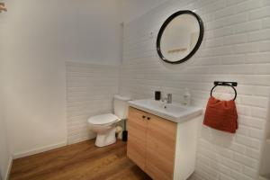 een badkamer met een toilet, een wastafel en een spiegel bij Appartement cosy à 50 m de la plage et du port in Mèze