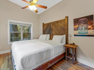 a bedroom with a large bed with a ceiling fan at Pilot Cove in Pisgah Forest