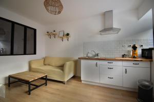 una cucina con divano e sedia in una camera di Appartement cosy à 50 m de la plage et du port a Mèze