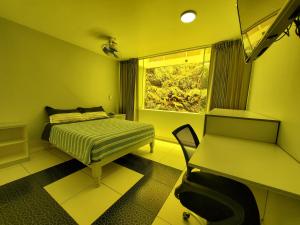 um quarto com uma cama, uma secretária e uma janela em Hotel Real San Pedro em El Puente