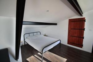 1 dormitorio con 1 cama y armario de madera en Studio industriel à 50 m de la plage et du port, en Mèze