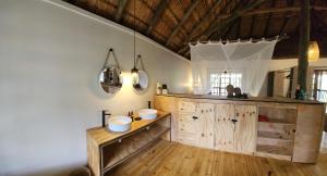 a bathroom with two sinks and a wooden cabinet at Amare Cabin in the bush with all your needs! in Marloth Park