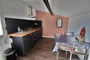 kuchnia ze zlewem i ceglaną ścianą w obiekcie Studio industriel à 50 m de la plage et du port w mieście Mèze