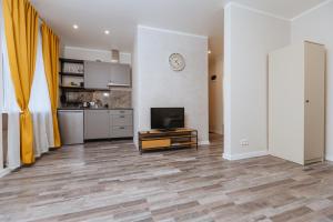 a living room with a television and a kitchen at Apartamenti Katrīna in Brocēni