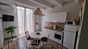 een keuken met een tafel en een witte koelkast bij Maison La Reggia in Caserta
