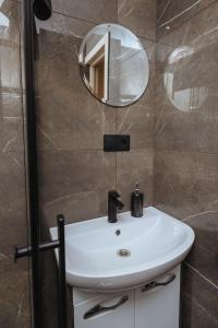 a bathroom with a white sink and a mirror at Apartamenti Katrīna in Brocēni