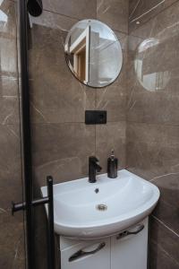 a bathroom with a white sink and a mirror at Apartment Katrina in Brocēni