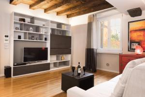 a living room with a large television and a couch at Flats4Rent Federica in Verona