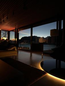 una sala de estar con una gran ventana de cristal y un sofá en VILLA KRISTINA / ÅNDALSNES, en Torvik