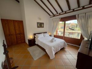 um quarto com uma cama e uma grande janela em Refugio Khalma de la Montaña em Villa de Leyva