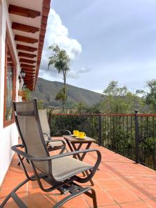 ein Stuhl und ein Tisch auf einer Terrasse mit Aussicht in der Unterkunft Refugio Khalma de la Montaña in Villa de Leyva