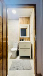 łazienka z toaletą, umywalką i telewizorem w obiekcie M&M Apartment Warsaw w Warszawie
