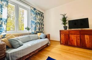 ein Wohnzimmer mit einem Sofa und einem Flachbild-TV in der Unterkunft M&M Apartment Warsaw in Warschau