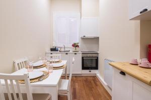 uma cozinha branca com uma mesa e cadeiras em Céntrico Apartamento Vigo- Oporto Luxury em Vigo