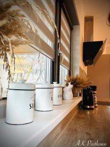 a row of white pots sitting on a window sill at Coast House 25 -TRZĘSACZ SUNNY SIDE BALTIC in Trzęsacz
