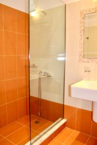 a shower with a glass door next to a sink at Peroulia Beach Houses in Koroni