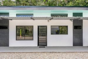 a white house with a black door and windows at Villas Anna Bertha in San Isidro de El General