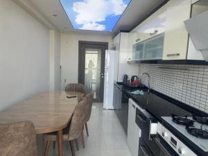 Apartment with nice View في بيليكدوزو: مطبخ مع طاولة وكراسي خشبية