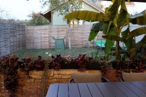 un jardín con mesa, sillas y una valla en Cozy Cottage - Free Parking, Self Check-in en Oradea