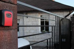 a black railing with a red mailbox next to a house at Cozy Cottage - Free Parking, Self Check-in in Oradea