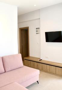 a living room with a couch and a flat screen tv at Peroulia Beach Houses in Koroni