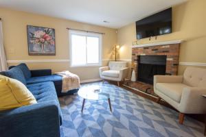 a living room with a blue couch and a fireplace at Sojourn Tree Lined Streets Newport News in Newport News