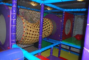 uma sala de jogos com um parque infantil com um escorrega em Villa Anna em Apsuciems