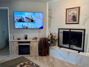 sala de estar con TV de pantalla plana sobre una chimenea en New Remodel Shuttle to AF Resort, en Angel Fire