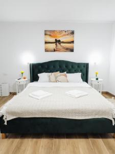 een slaapkamer met een groot bed met een groen hoofdeinde bij SubCetate in Sighişoara