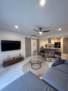 Playa Medano Caminando, Alberca en el roof في كابو سان لوكاس: غرفة معيشة مع أريكة وتلفزيون على الحائط