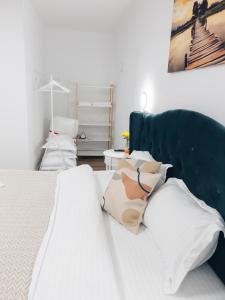 een slaapkamer met een wit bed met een blauw hoofdeinde bij SubCetate in Sighişoara