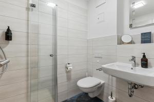 a white bathroom with a toilet and a sink at Vorstadtoase für 2 - Netflix, Parkplatz, Nähe BER, Queensize-Bett in Eichwalde